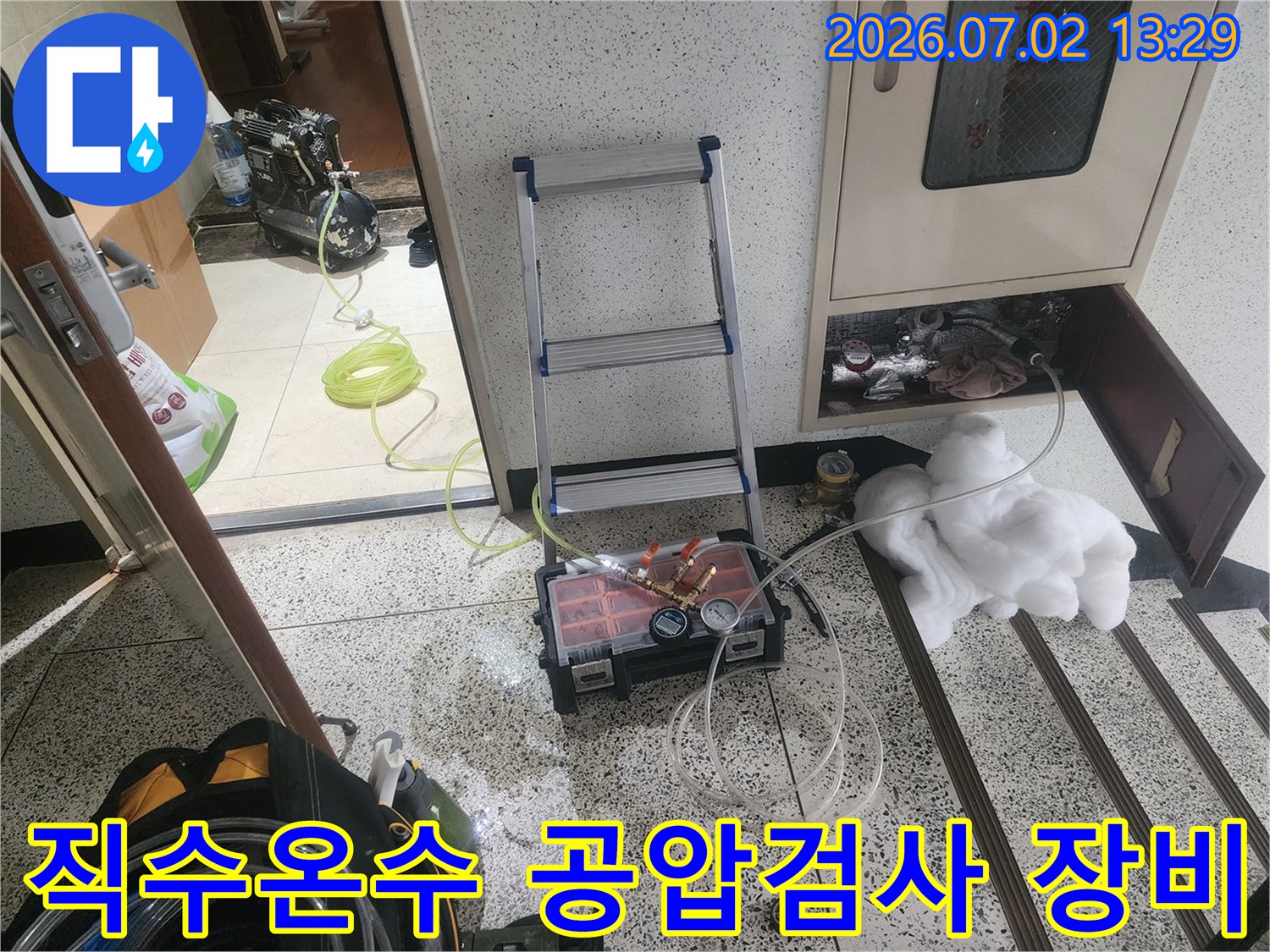 이 이미지는 울산 우정동에서 온수배관 누수 진단을 위해 공압검사 장비를 설치하고 있는-전문 엔지니어의 모습을 보여줍니다.