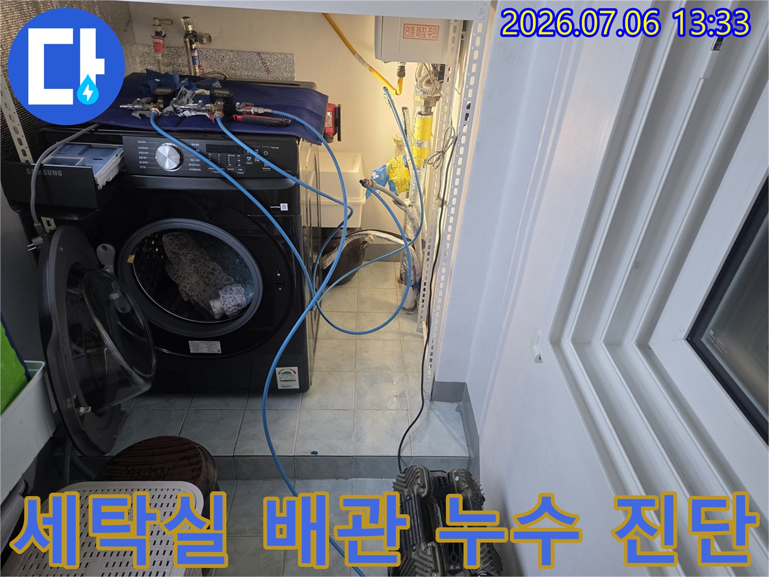 복잡한 배관이 노출된 세탁 공간에서 정밀 점검을 수행하는 현장 사진
