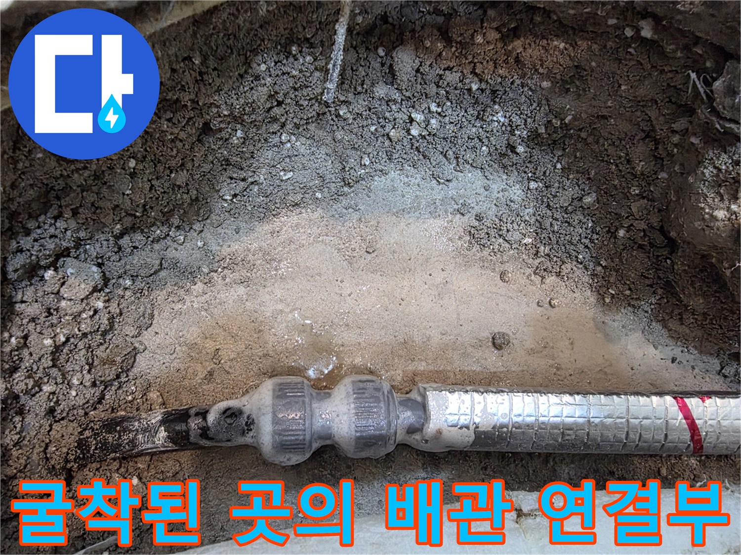 콘크리트 층 아래 노출된 은색 보온재가 감싸진 배관 사진