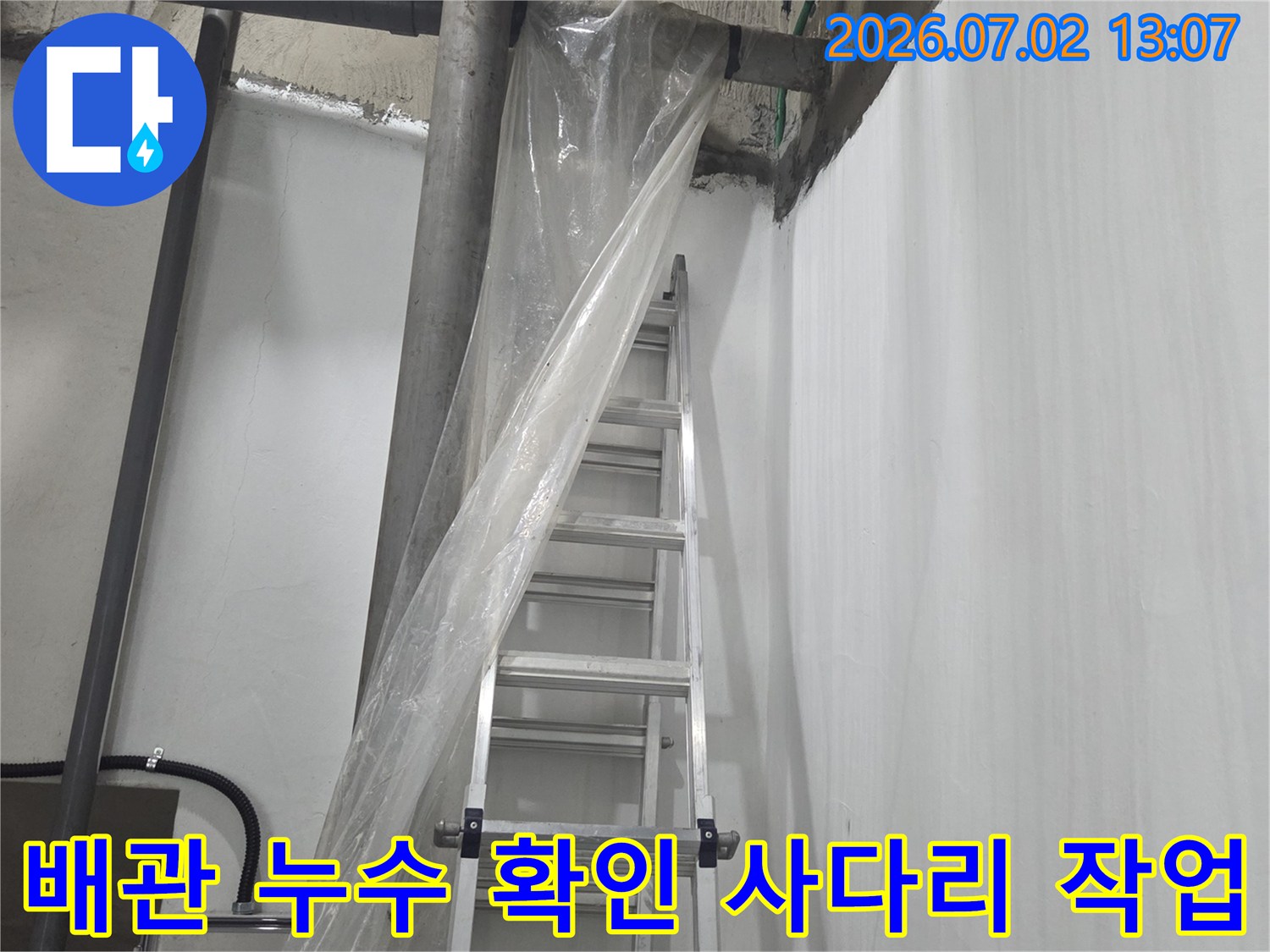 비닐로 보양된 구간과 천장 배관-누수 탐지를 위해 배치된 알루미늄 사다리