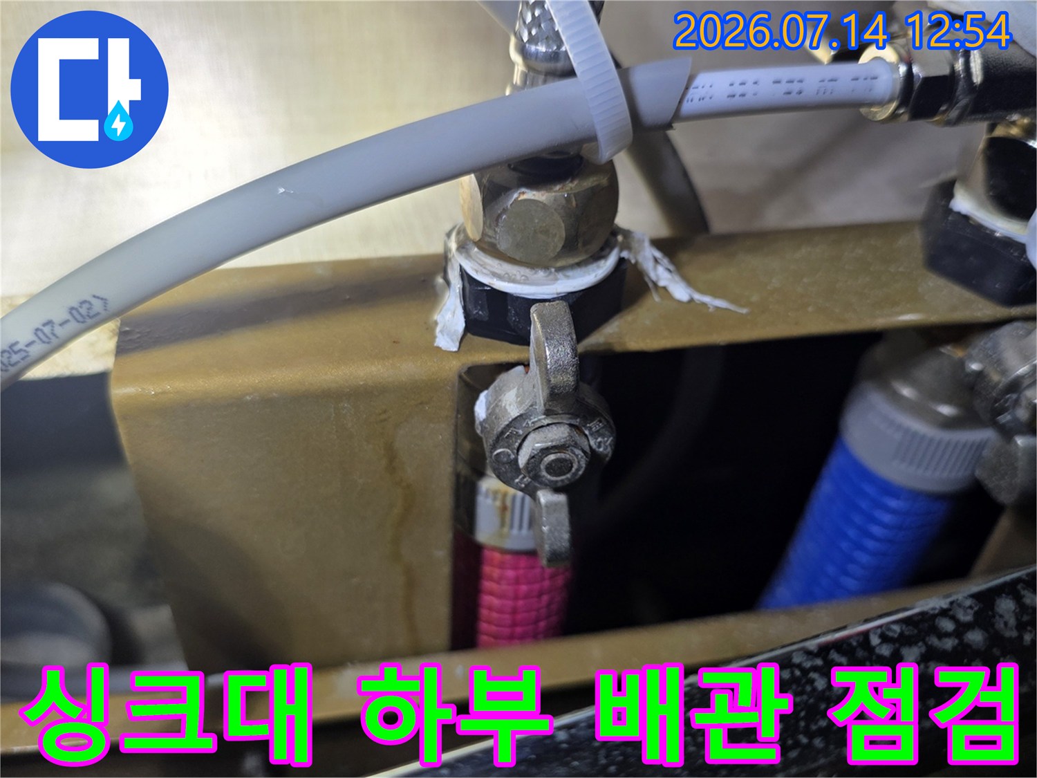 싱크대 밑 급수 및 온수 배관 연결 부위 정밀 점검 모습