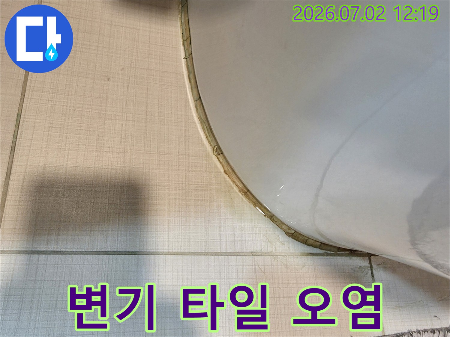 변기 하단부 타일의 오염과-백시멘트의 변색은-지속적인 누수로 인한 손상을 보여줍니다.
