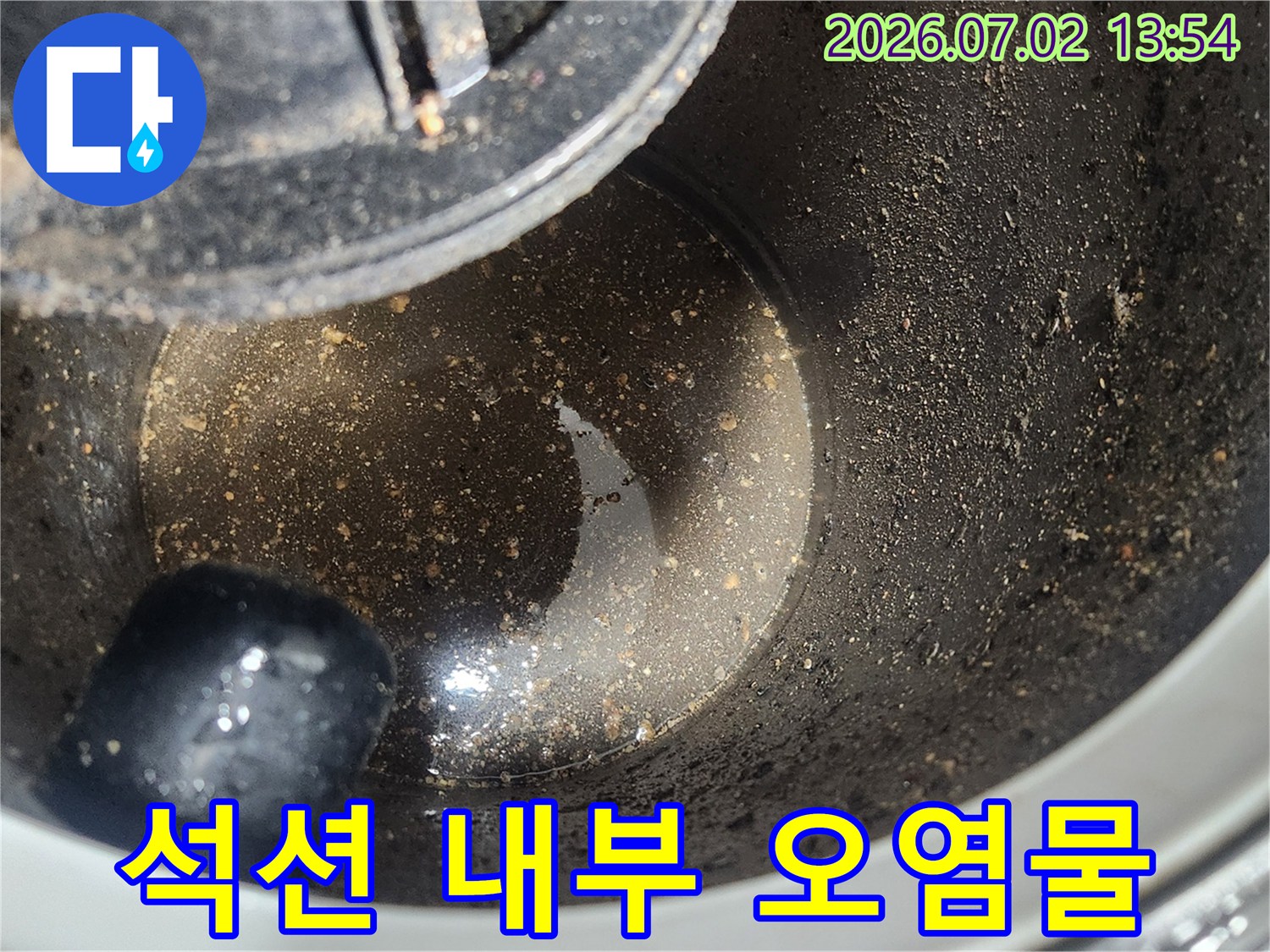 배관 스케일링 1차 작업 후-석션 장비 내부에 포집된-굳은 기름층과 오염물질을 보여주는 클로즈업 사진
