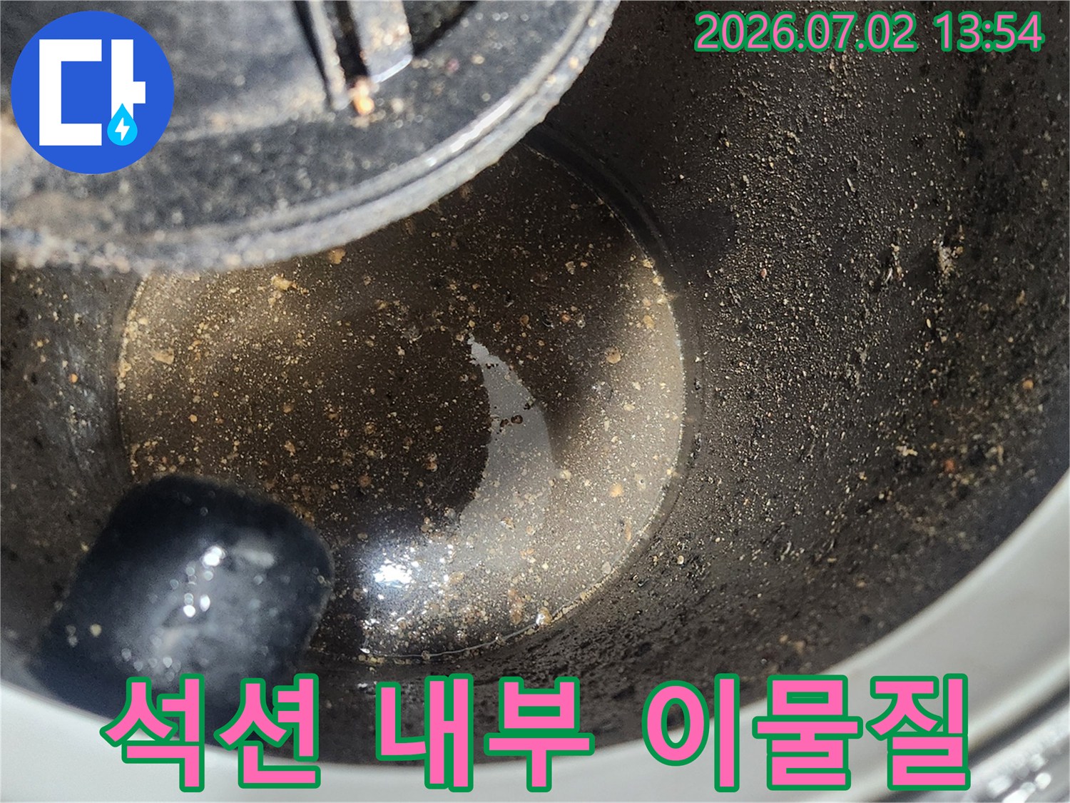 배관 스케일링 1차 작업 후-석션 장비 내부에 흡입된-굳은 기름 슬러지와 이물질을 보여주는 사진