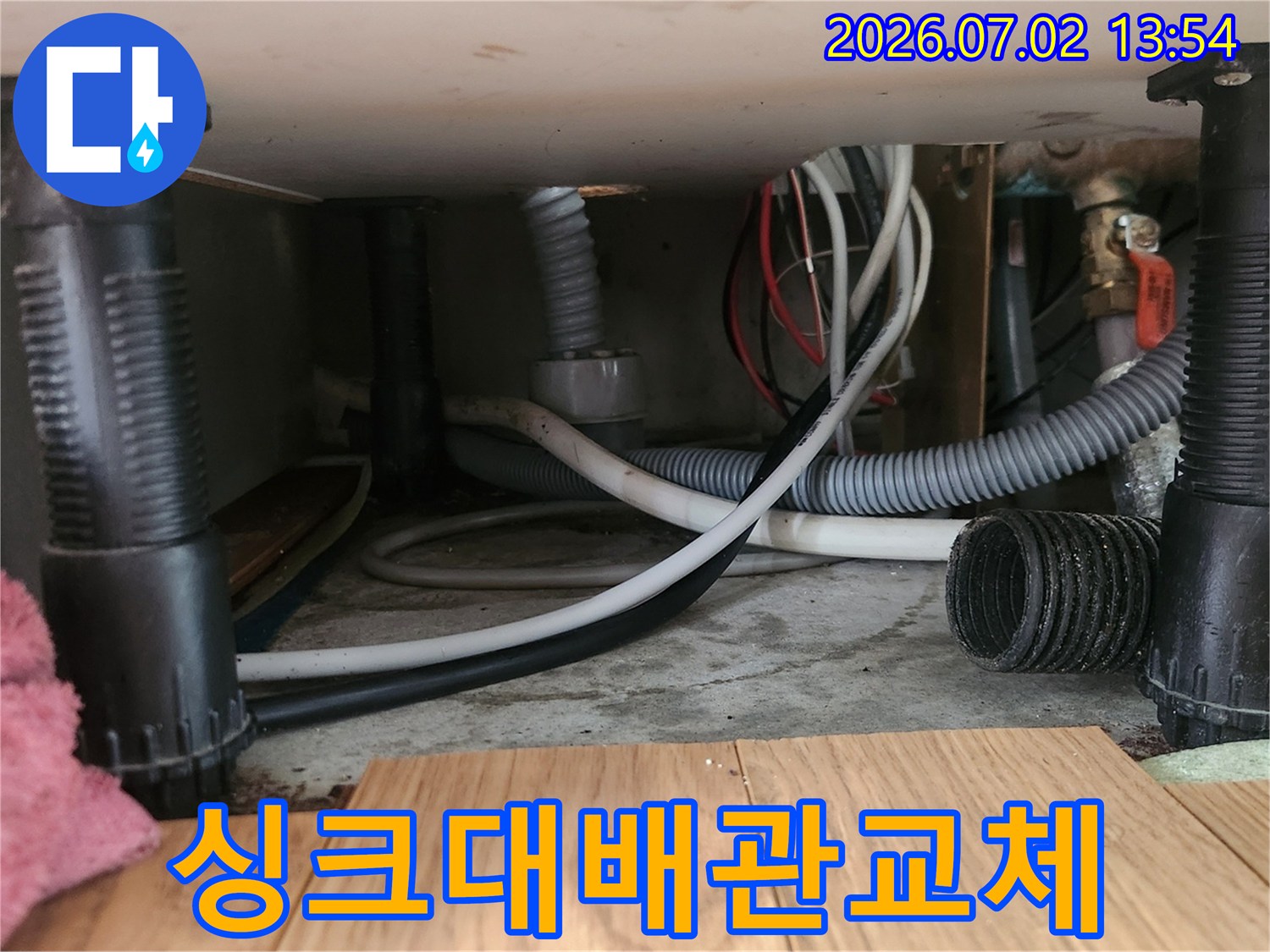 싱크대-하부-공간에서-오래된-배수-호스를-제거하고-새로운-호스로-교체하는-작업-과정을-보여줍니다.