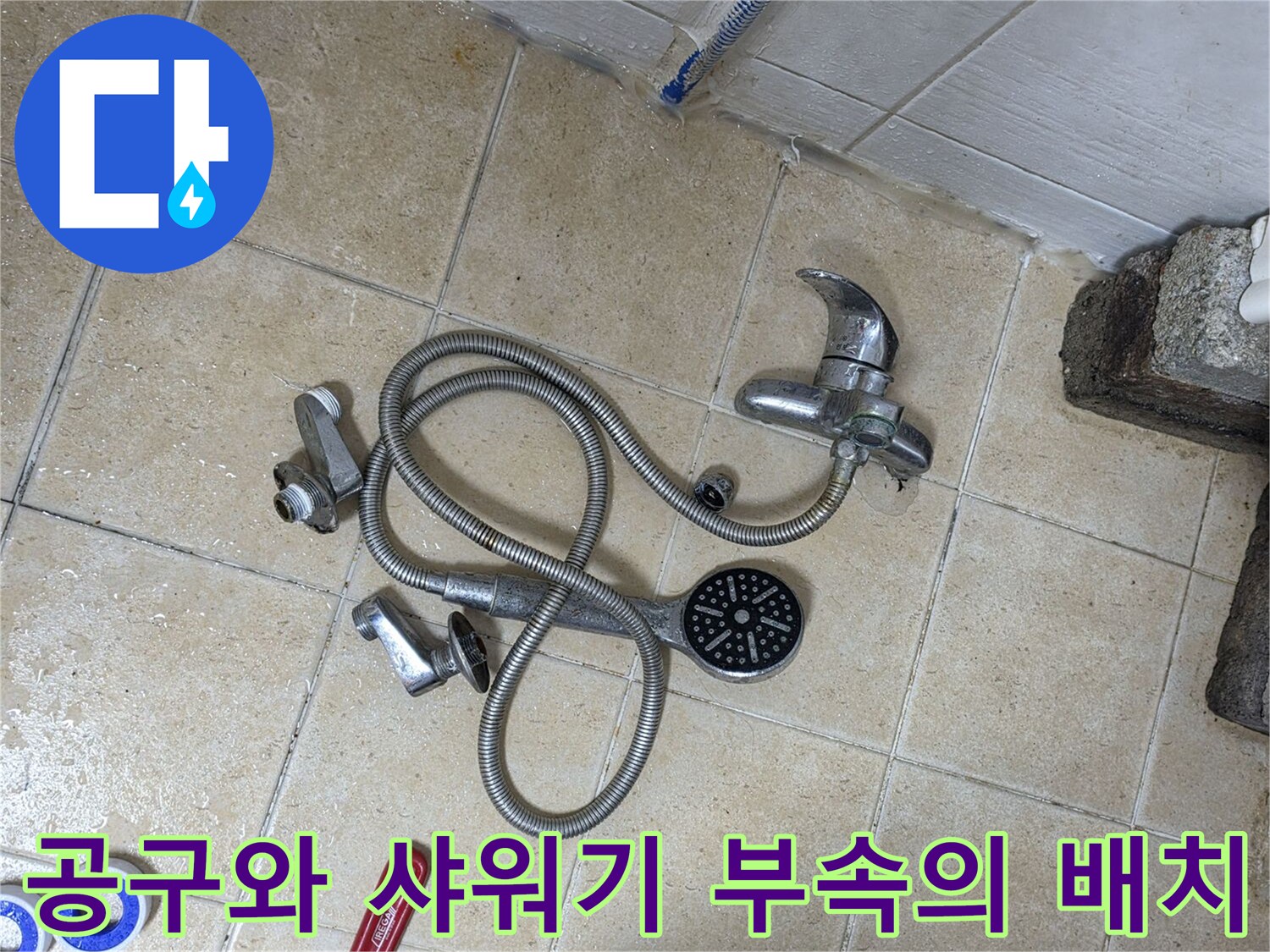 바닥에 놓인 몽키스패너와 분해된 샤워기 수전 세트