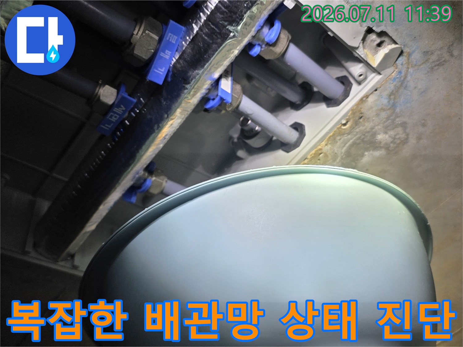 노후된 파란색 커플링과 여러 갈래의 배관이 얽힌 구조물