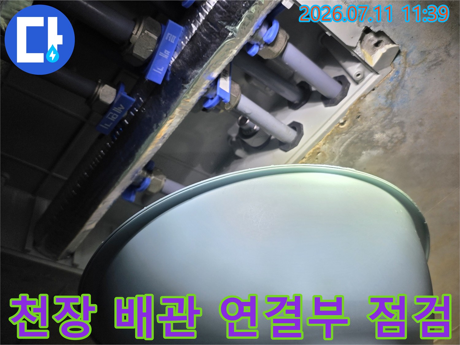 파란색 밸브와 배관이 노출된 천장 내부 구조물