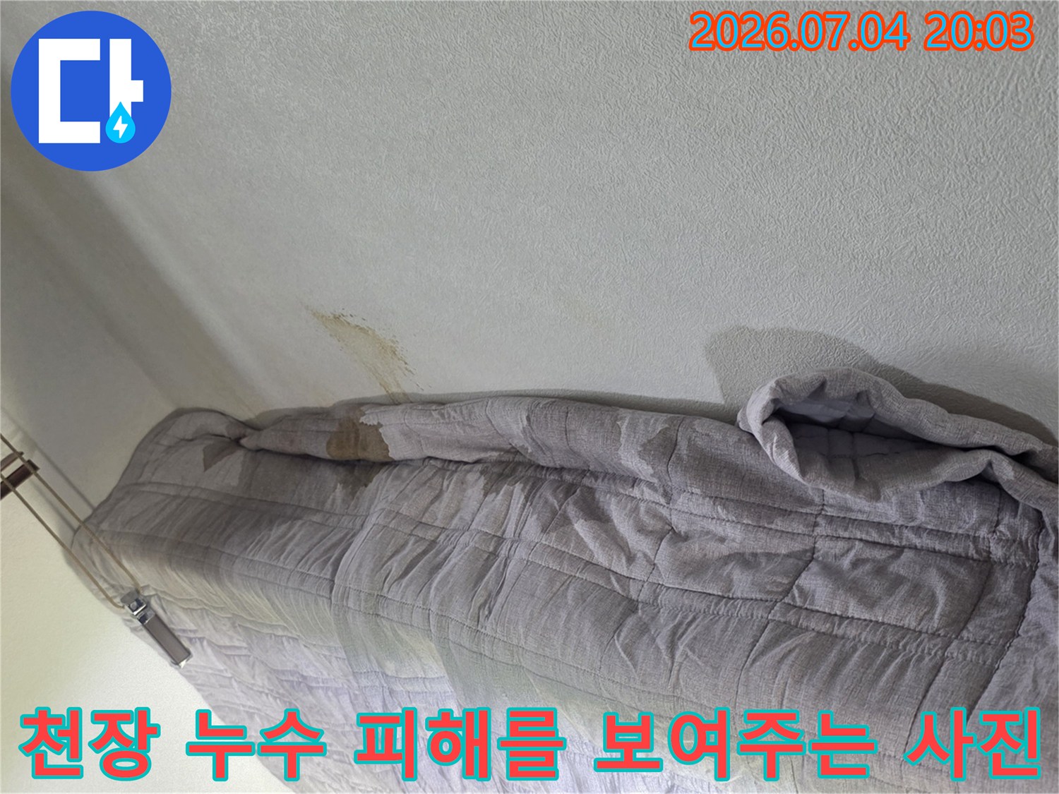 누수로 인한 천장 얼룩과 보양용 덮개로 보호된 상태의 장면