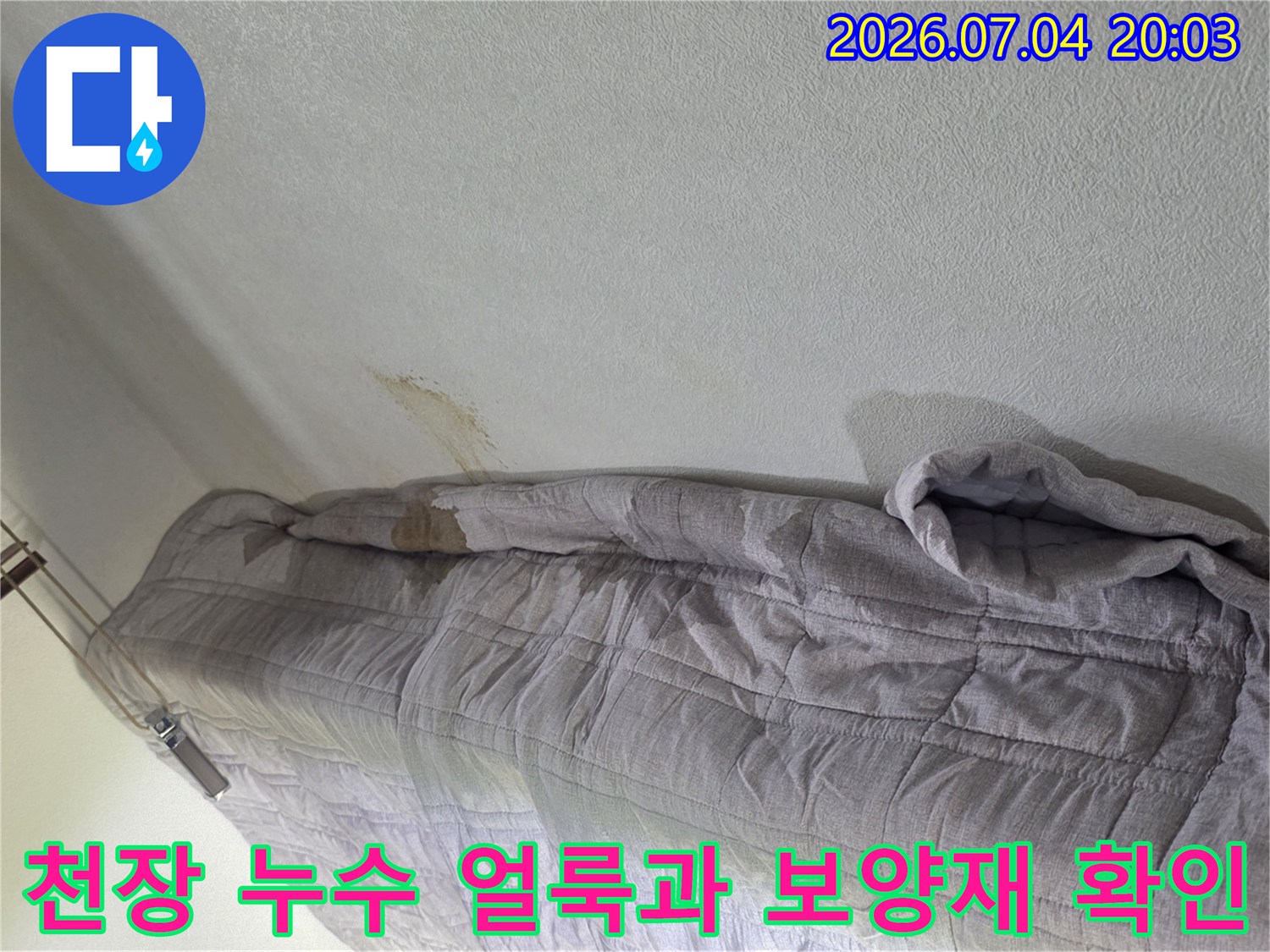 누수로 인한 천장 얼룩과 보호용 덮개로 가려진 배관 부근