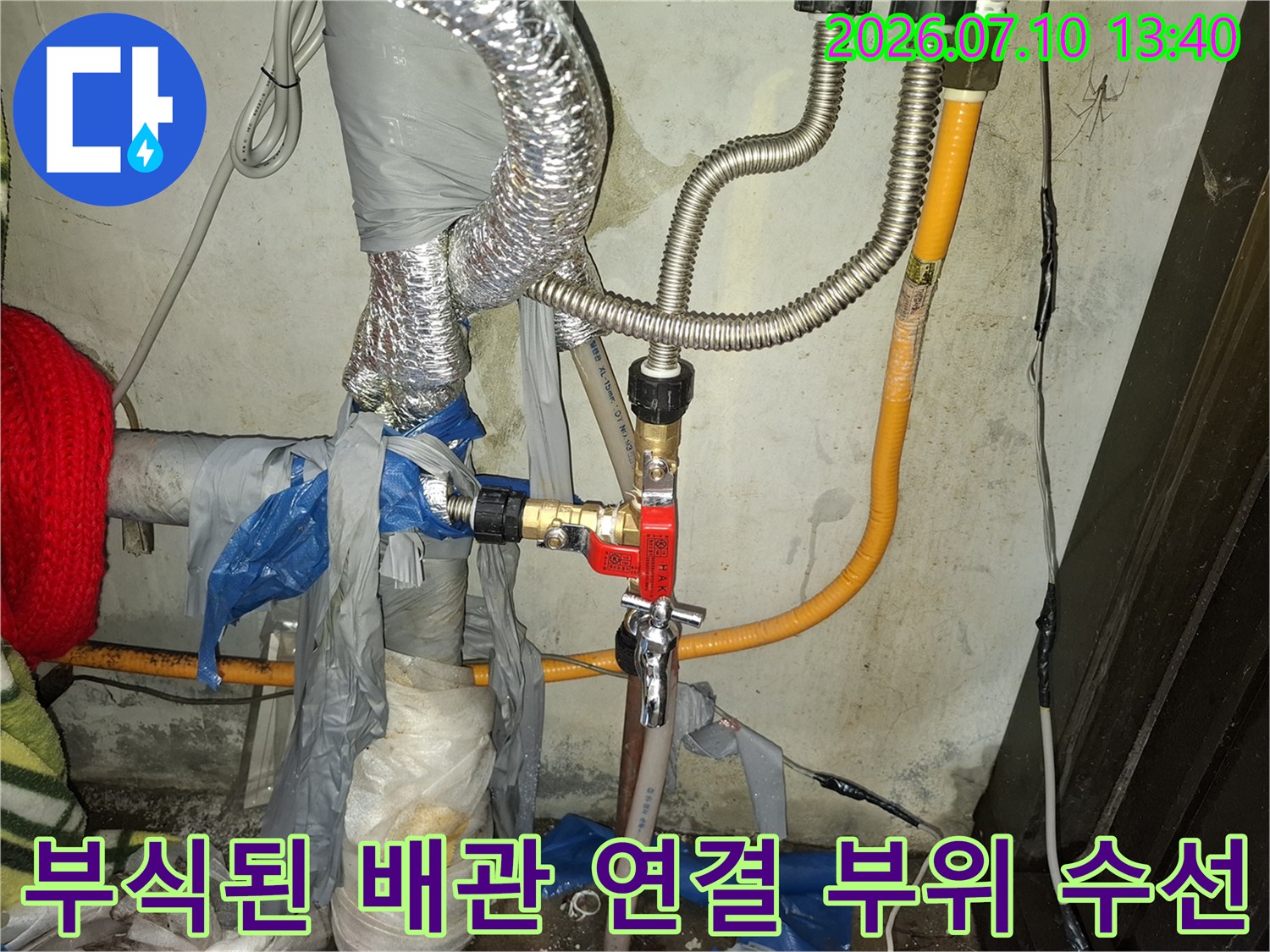 거친 질감의 노후 금속 배관과 새 밸브가 대비되는 누수 공사 장면