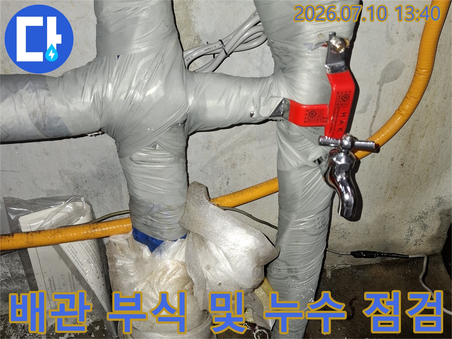 보온재를 제거하고 노출된 금속 배관 연결부의 부식 상태 확인