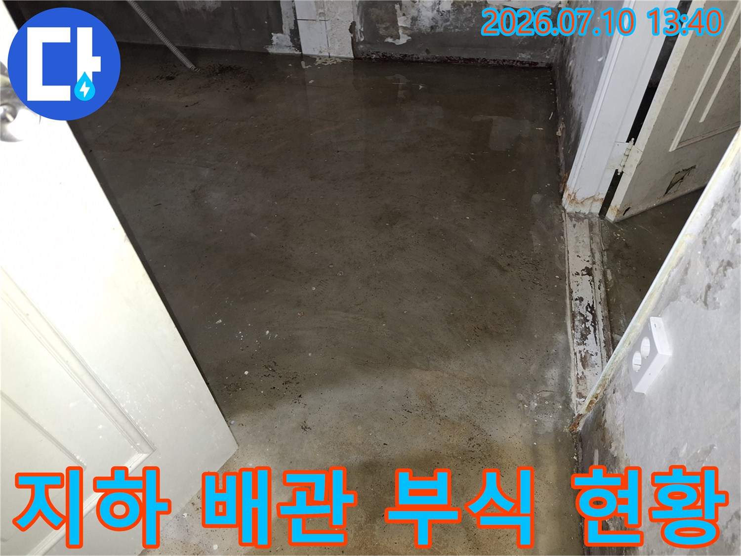 부식된 금속 배관이 노출되어 누수가 발생한 지하 공간의 모습입니다.