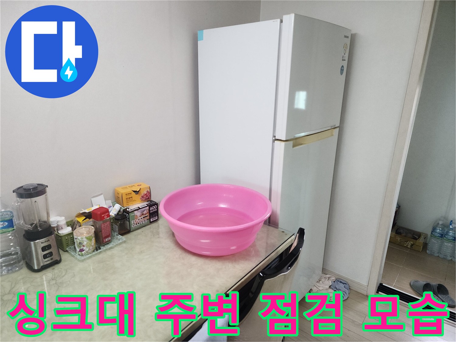 싱크대 상판 위 물건들과 냉장고 측면을 촬영한 사진입니다.