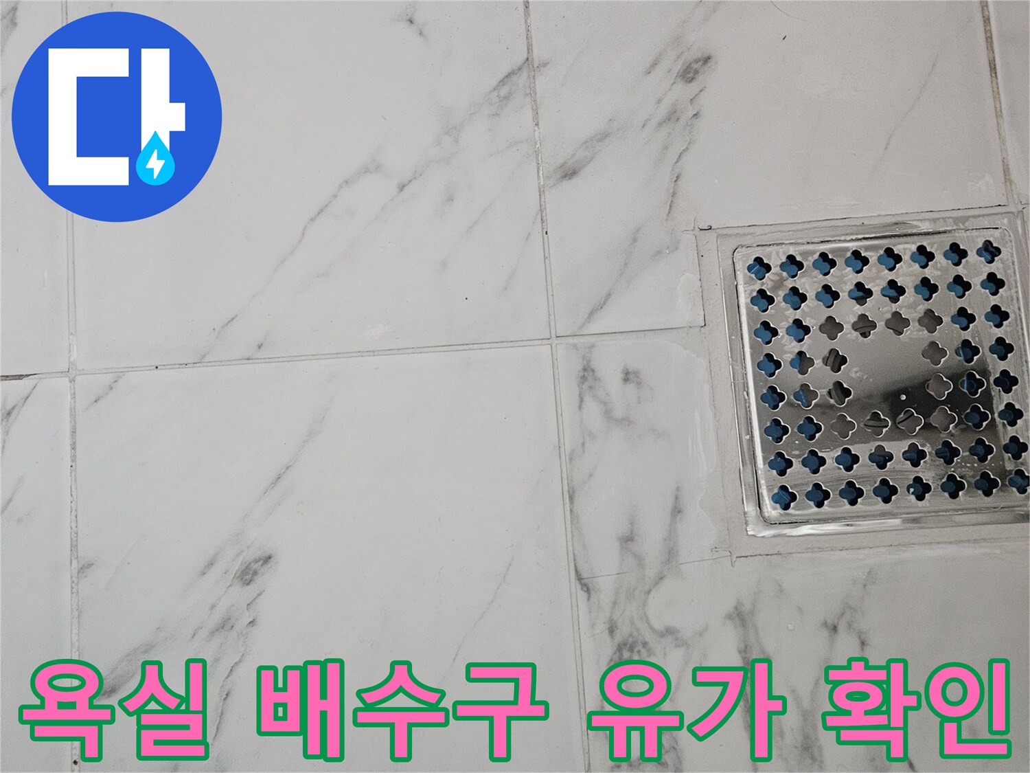 금속 유가 덮개와 대리석 패턴 타일이 만나는 지점의 모습