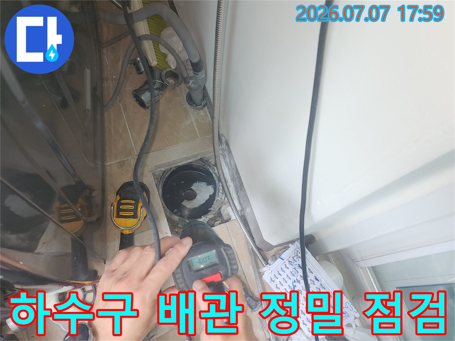 전문 장비를 사용하여 세탁실 하수관 주변의 누수 여부를 정밀하게 측정하는 모습