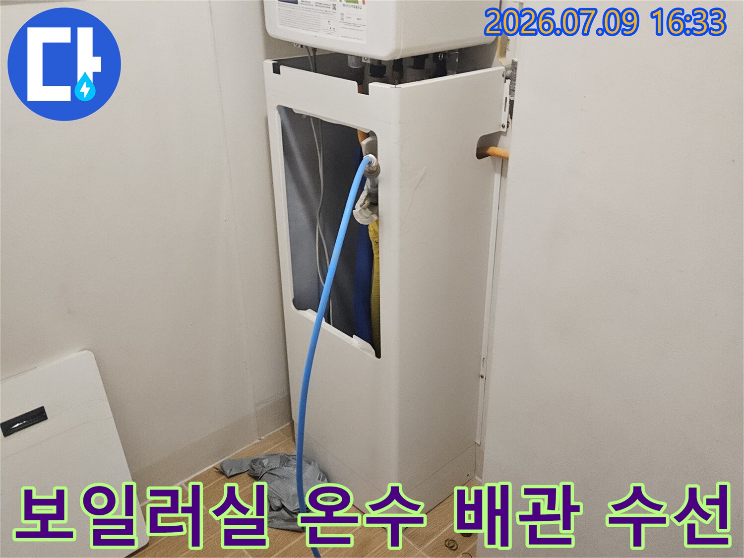 보일러실 내부의 노출된 파란색 온수 배관 교체 작업 모습