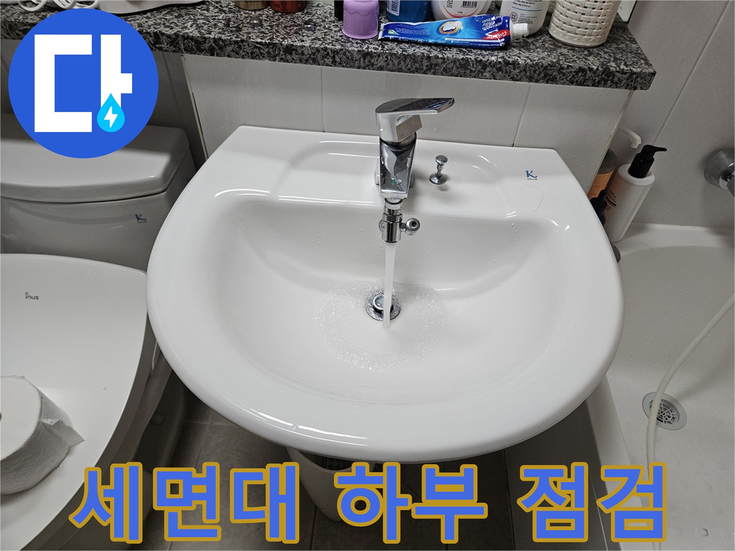세면대 아래 은색 부속품과 연결된 배관의 모습입니다.