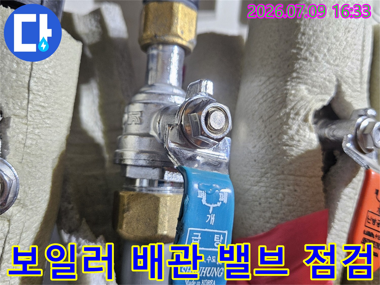 온수 라인과 파란색 수동 조절 장치의 상세 전경