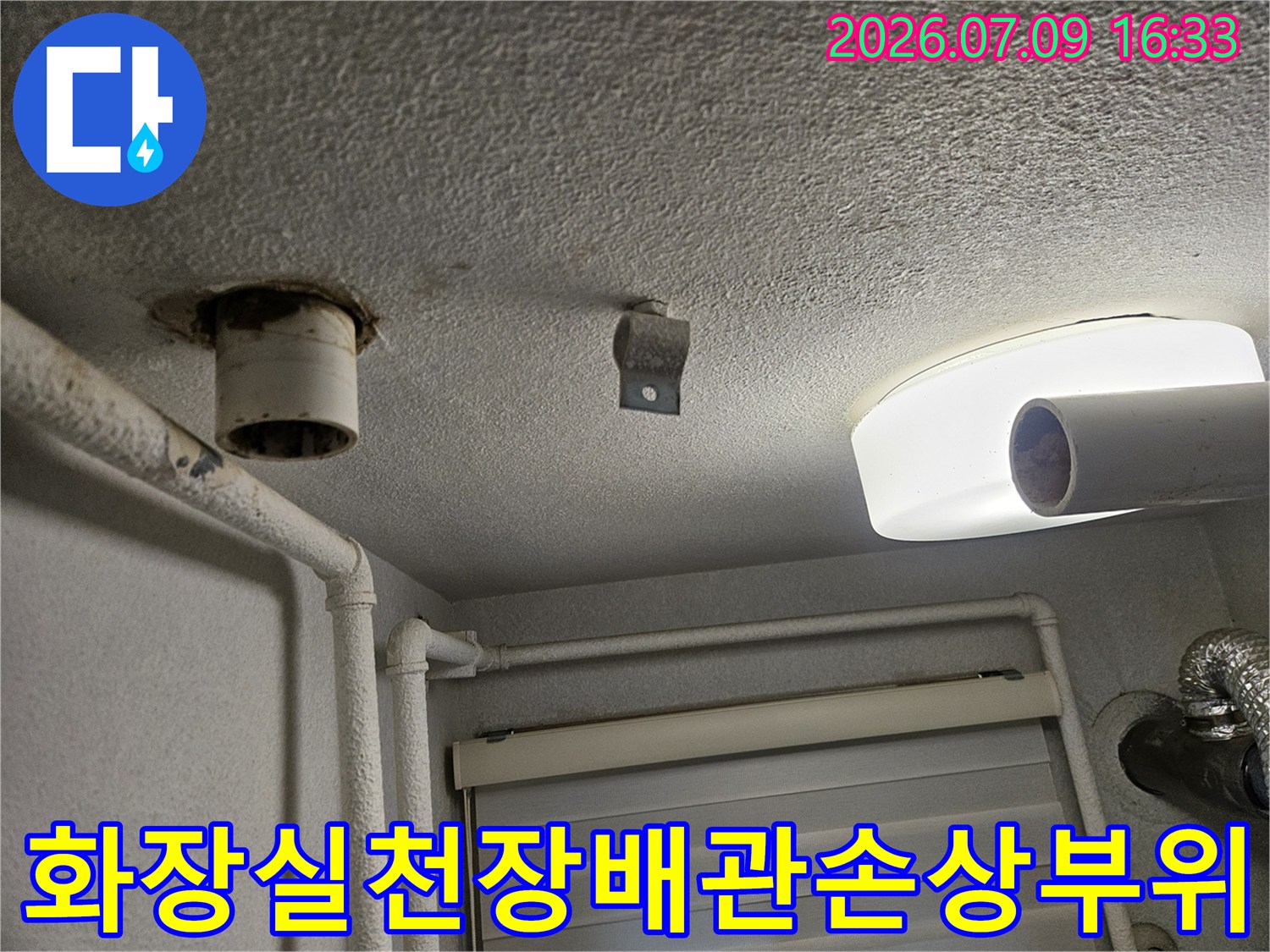 화장실 천장의 배관 연결 부근과 마감재 변형 상태를 촬영한 사진
