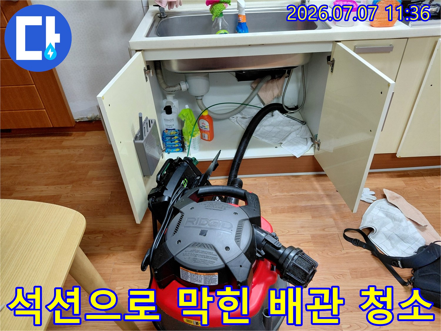 싱크대 하단 배수구에 석션 장비를 연결하여 내부 오물과 찌꺼기를 흡입하는 모습