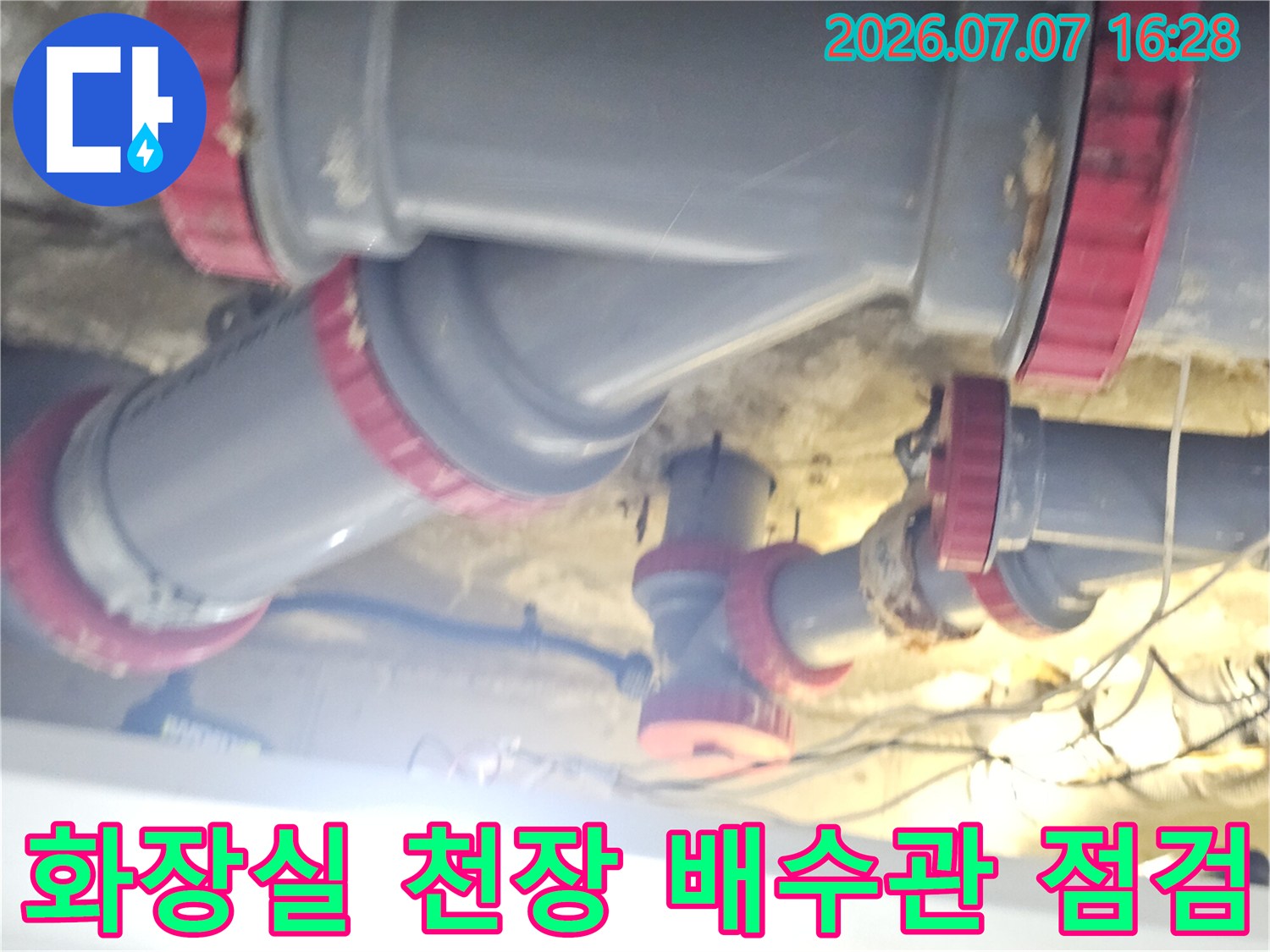 붉은색 밴드로 마감된 화장실 천장 내 배수 배관 연결부위 상세 사진