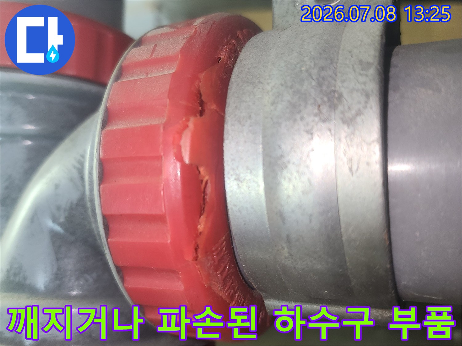 붉은색 소재구가 깨진 상태의 배관 연결부 교체 작업 전