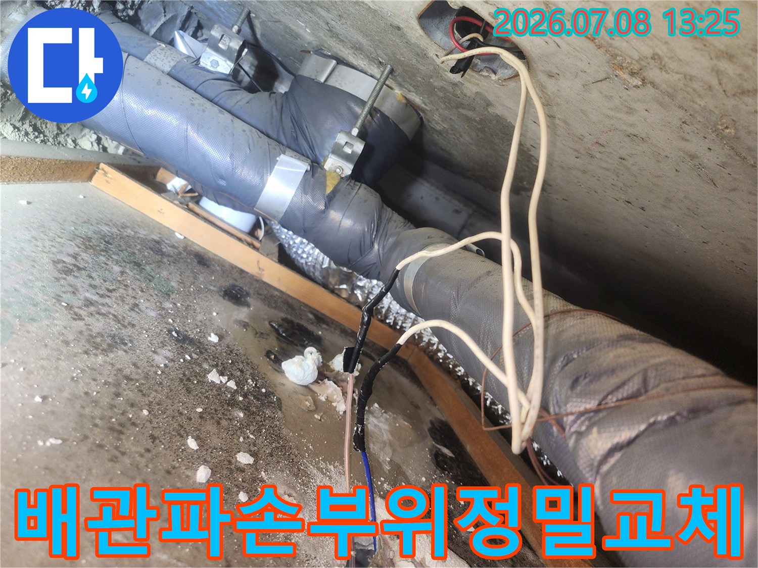 화장실 천장 내 배수 배관의 파손된 부품을 제거하고 새 제품으로 교체하는 모습