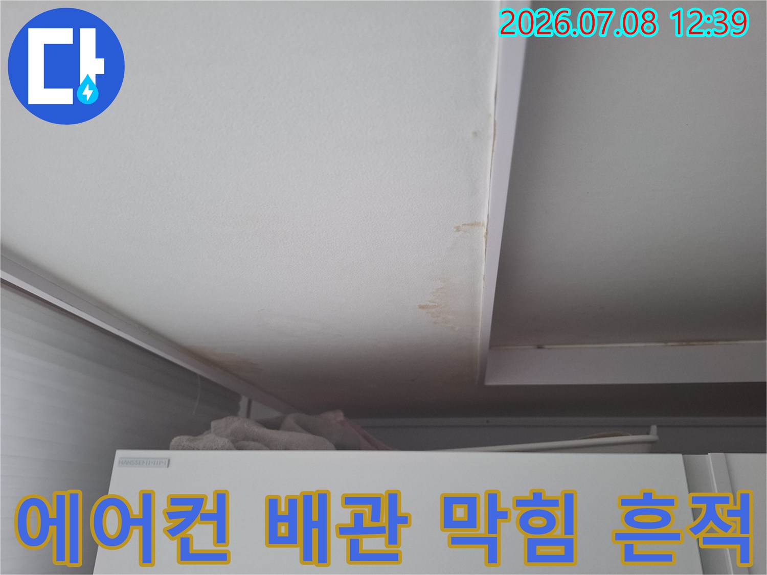 배수 불량으로 인해 천장에 형성된 누수 오염 부위의 근접 촬영
