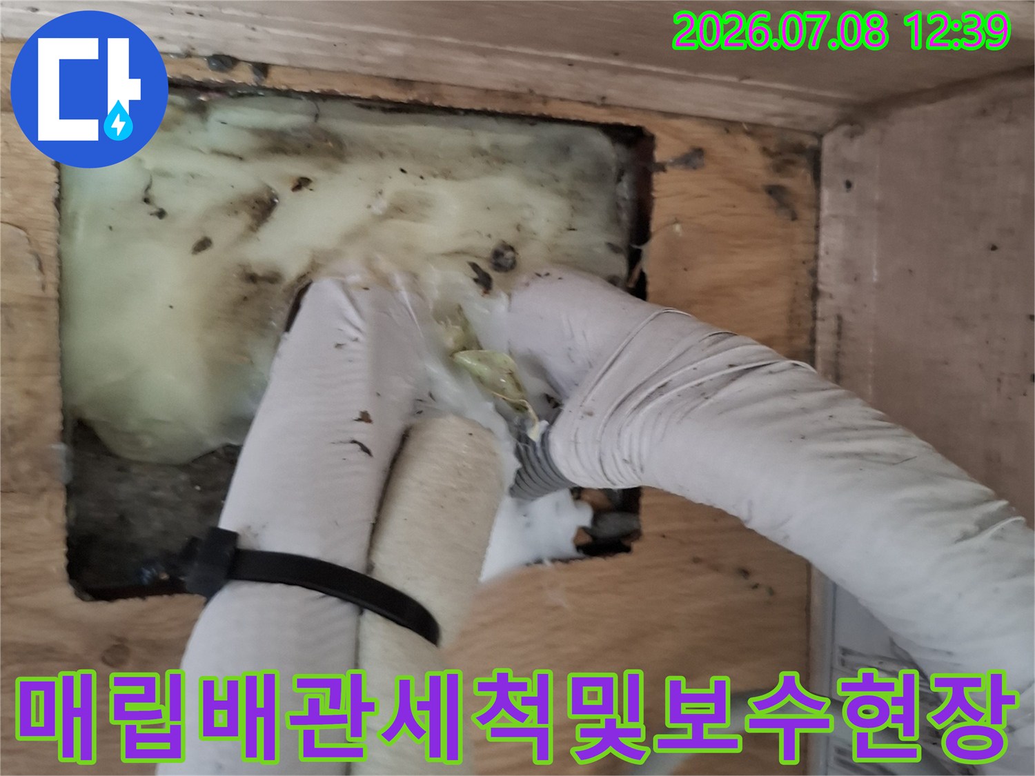 장비를 활용하여 매립된 에어컨 배출 배관의 막힘을 해결하는 모습