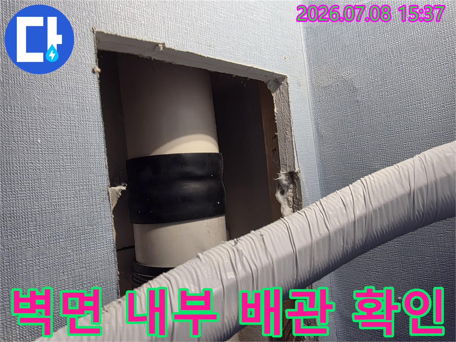 노출된 벽체 내부에 위치한 에어컨 드레인 호스와 검은색 테이핑 마감 부위의 상세 모습