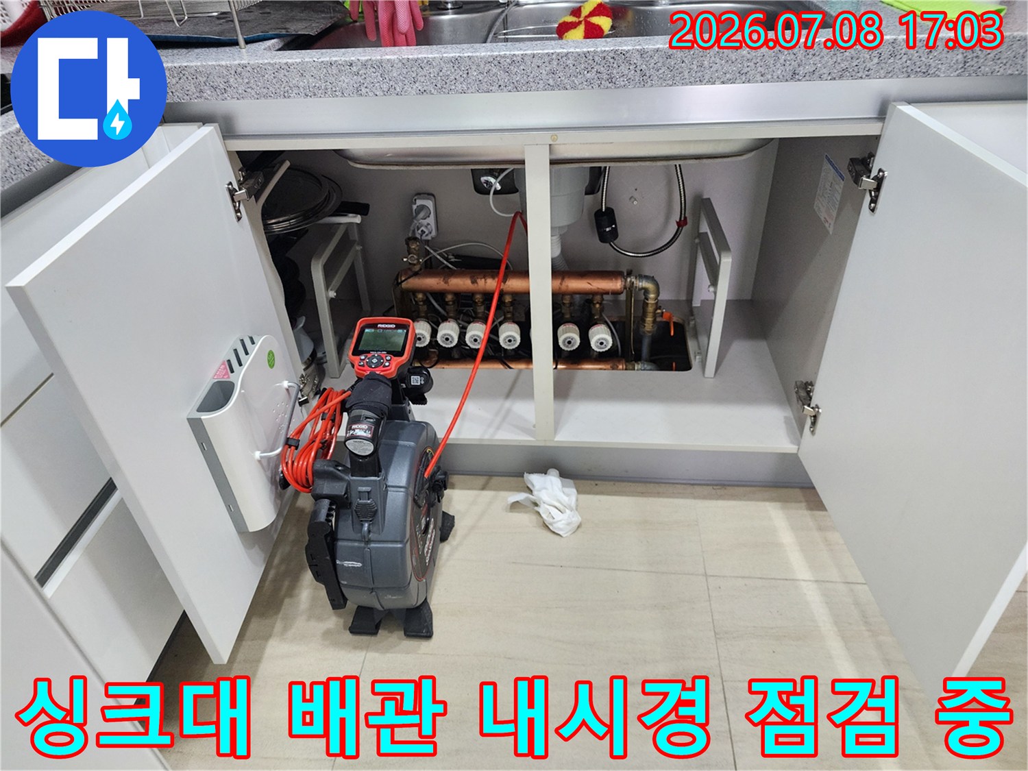 전문가용 내시경 장비로 싱크대 하부의 복잡한 배관을 정밀하게 조사하는 모습