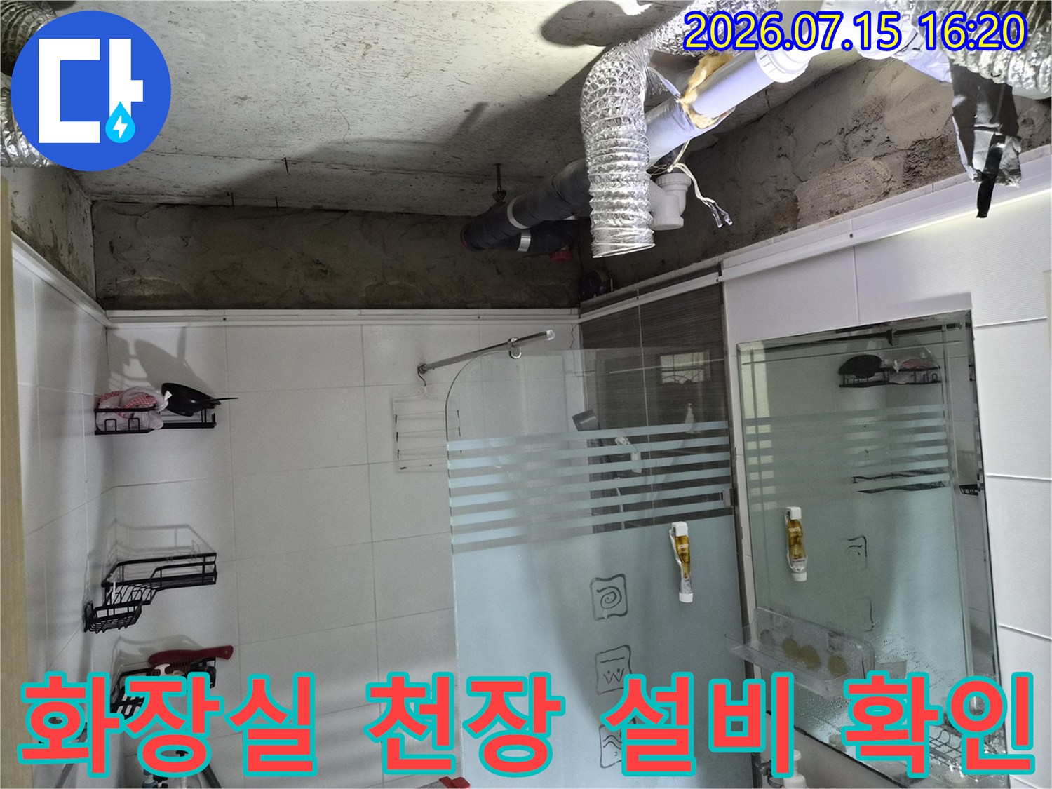 화장실 천장 내부 노출된 배관과 공기 순환용 덕트의 점검 모습