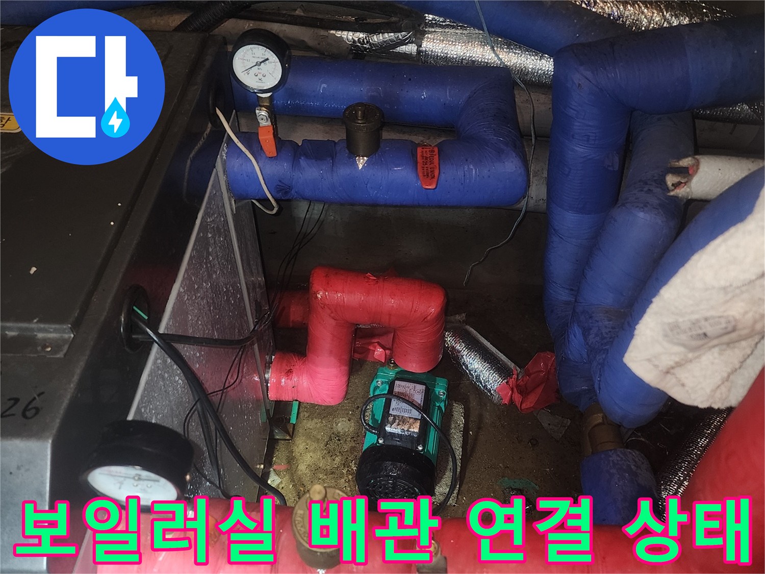 붉은색과 푸른색 보온재가 씌워진 배관이 교차하는 지점의 근접 촬영