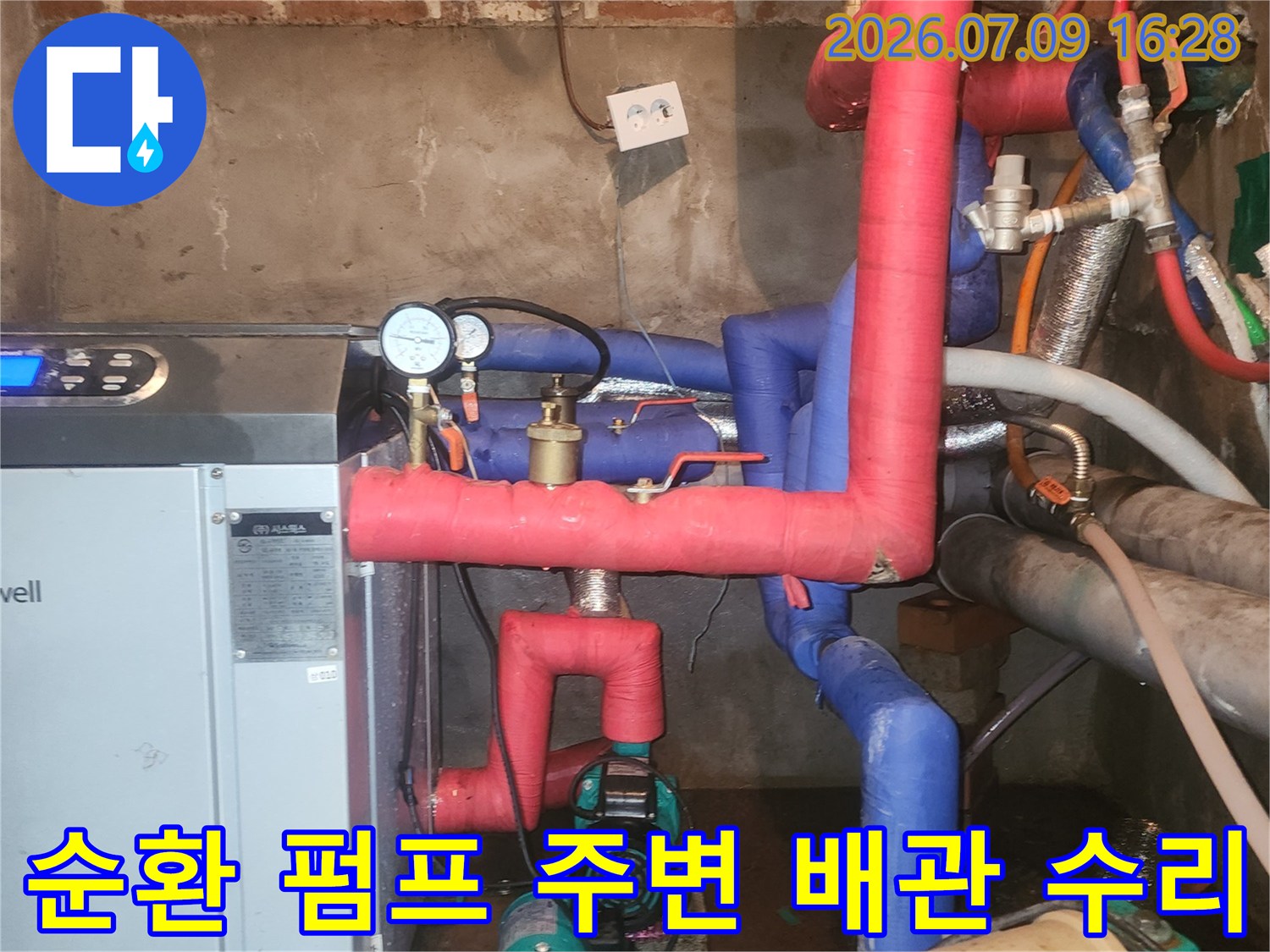 빨간색과 파란색 배관이 연결된 보일러실의 핵심 설비 점검 모습