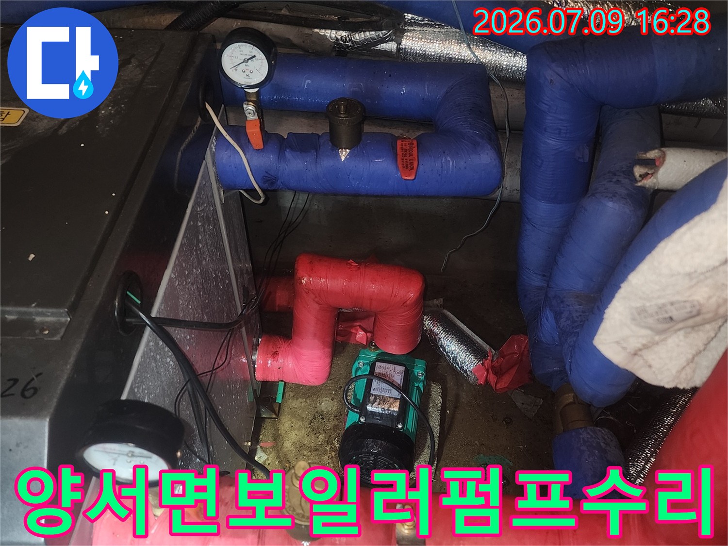 빨간색과 파란색 배관이 연결된 펌프 부위의 누수 수리 현장