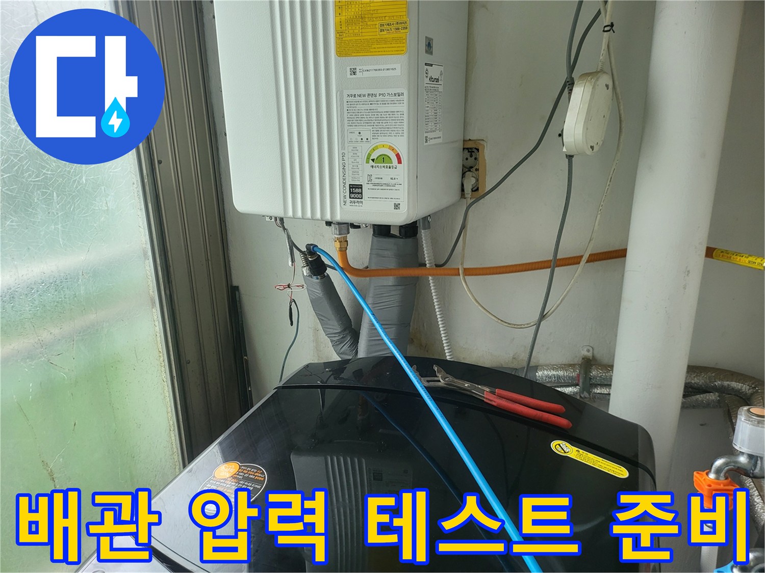 보일러 하단 배관에 연결된 파란색 점검용 호스