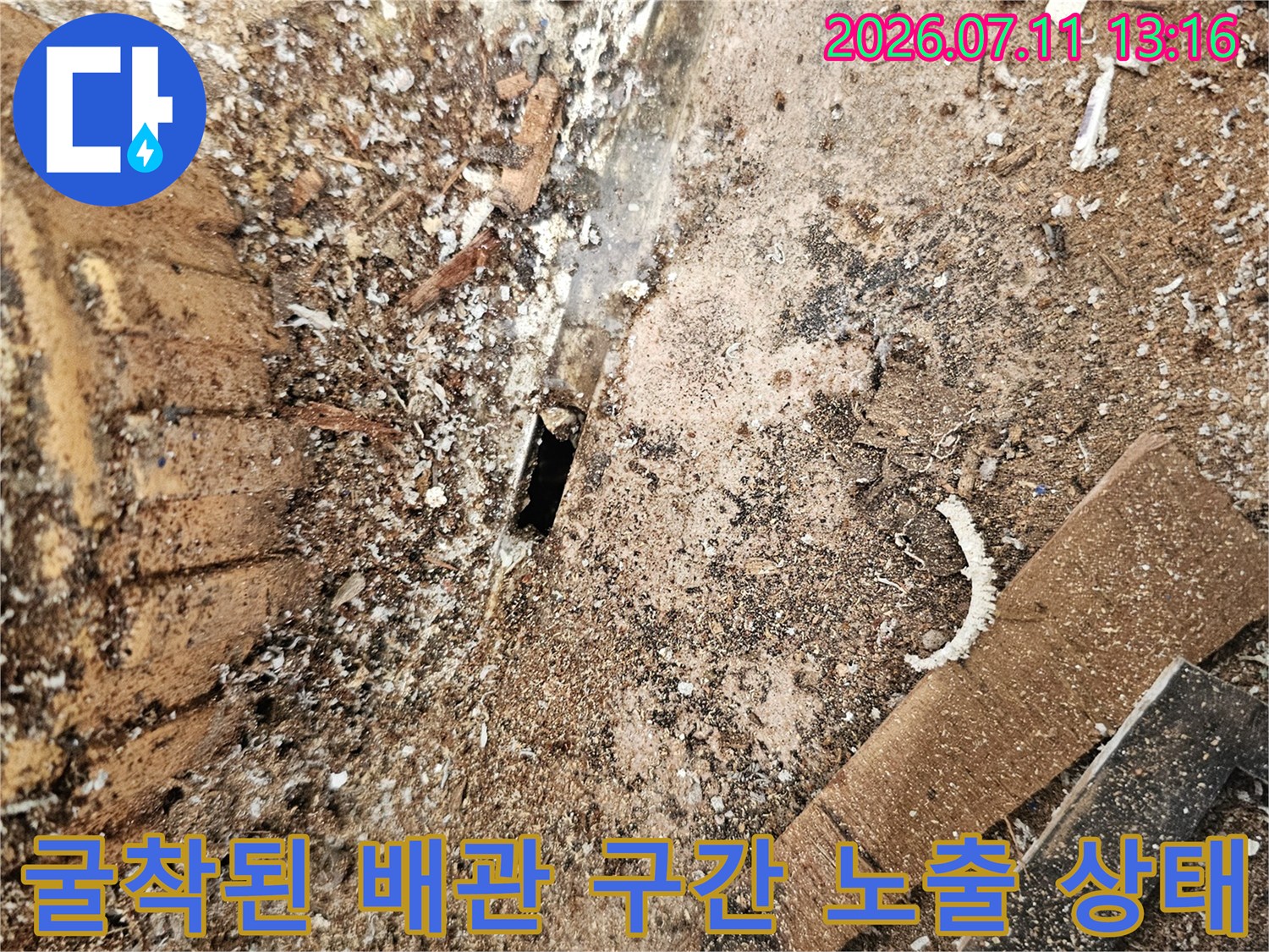 흙이 쌓인 채로 드러난 배관과 주변 틈새의 상세 모습