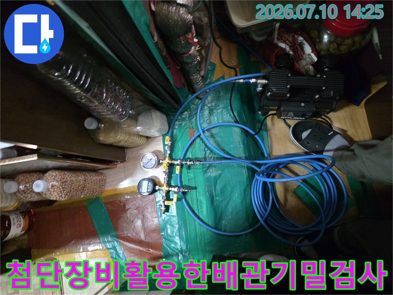 공압 테스트 장치와 파란색 호스를 사용하여 배관의 누수를 정밀 점검하는 모습