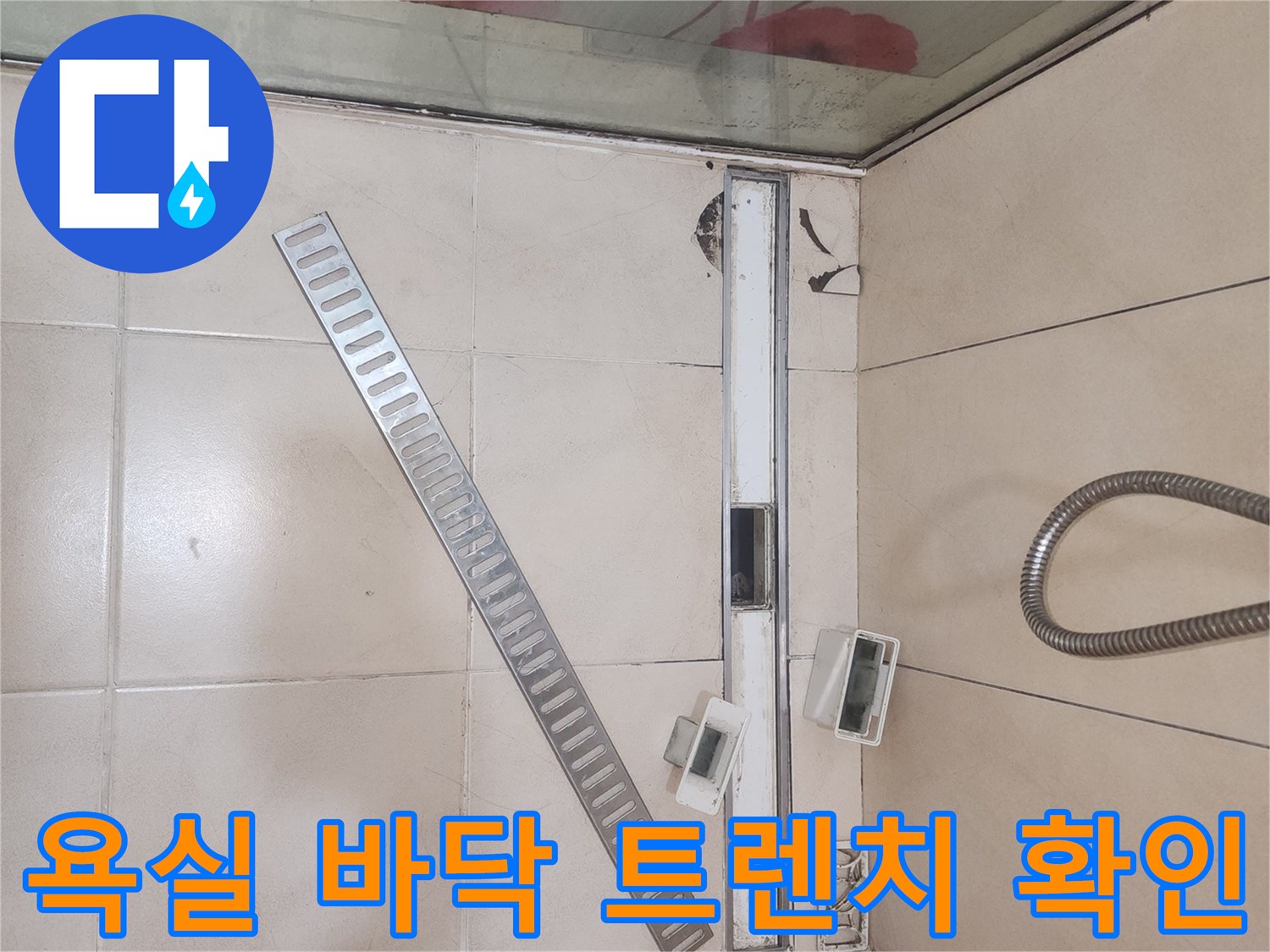 화장실 배수용 트렌치와 주변 타일의 근접 촬영