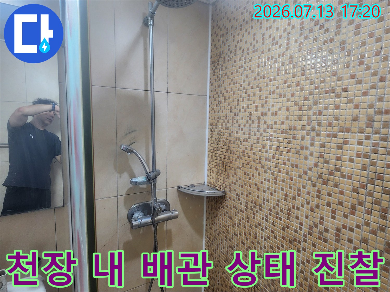 화장실 천장 안쪽으로 노출된 배관의 연결부와 주변 환경을 점검하는 모습