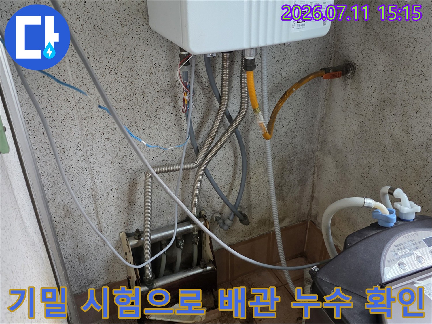 보일러실 내 복잡하게 얽힌 배관에 공압 장비를 연결하여 기밀 상태를 정밀 측정하는 모습