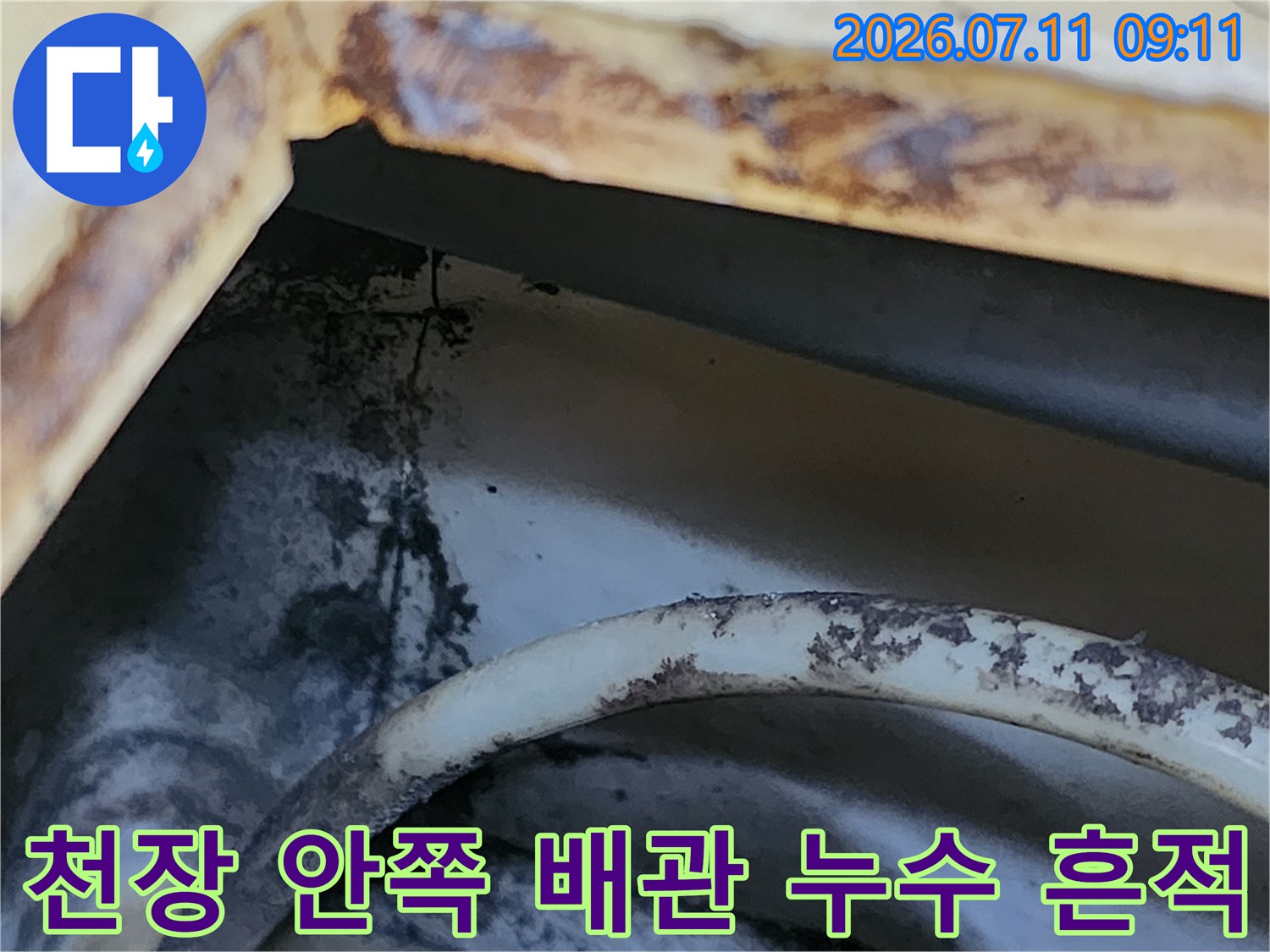 배관 주변의 노후된 마감재와 갈색으로 변한 누수 자국