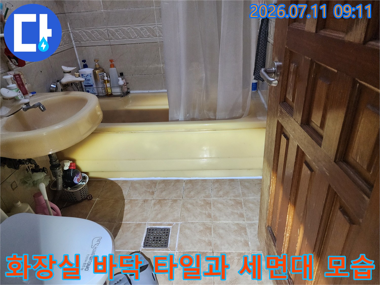 세면대가 설치된 화장실 내부와 노란색 트렌치 배수구 영역