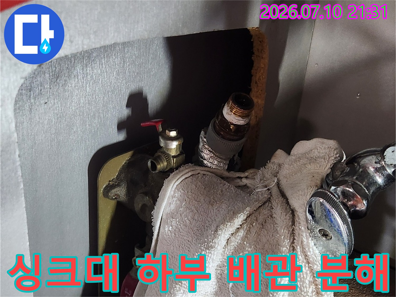 싱크대 아래쪽 위치한 온수 앵글밸브를 탈거하여 배관을 노출시킨 장면