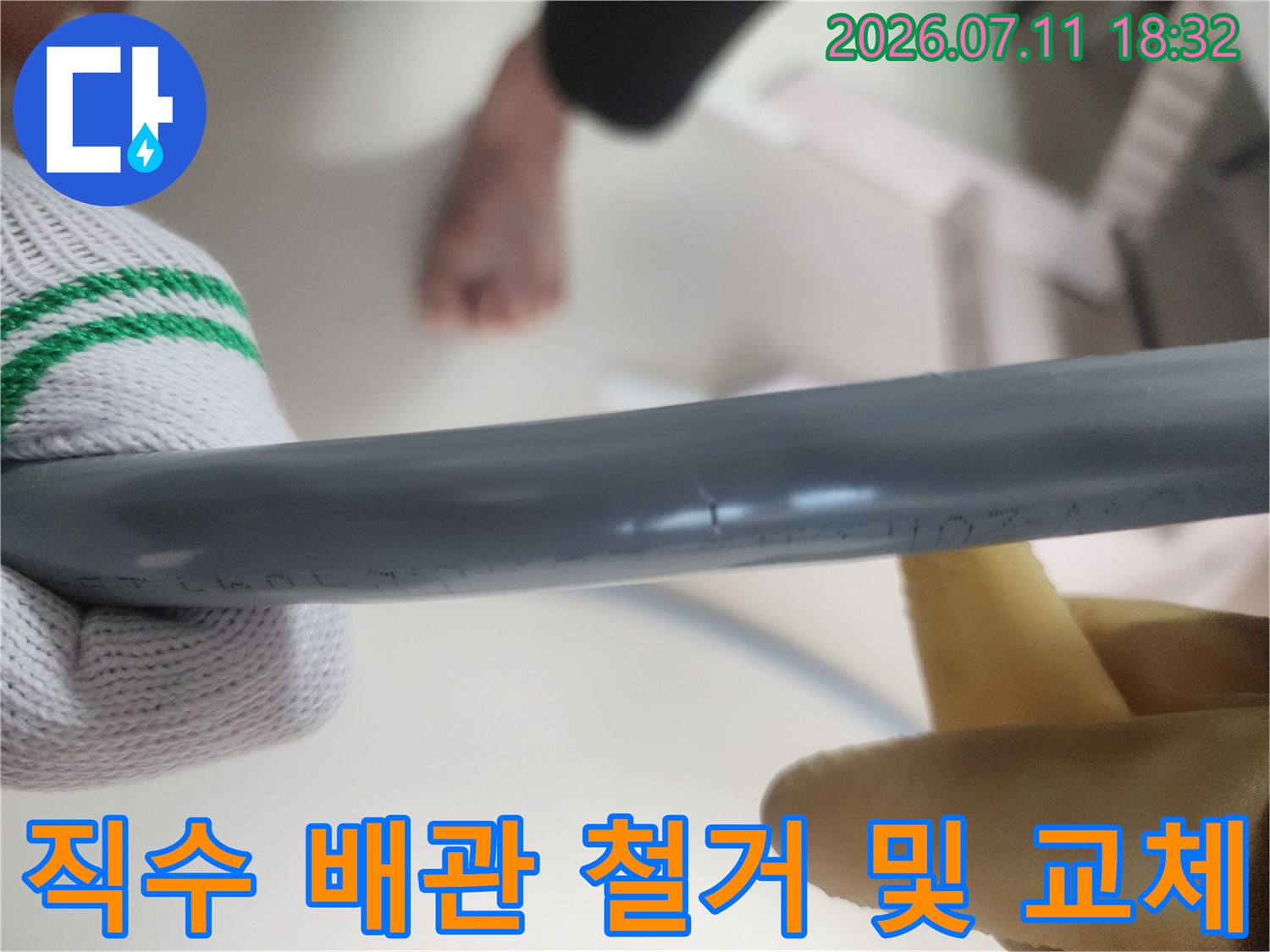 장갑 낀 손으로 회색 직수 배관을 제거하는 작업 사진