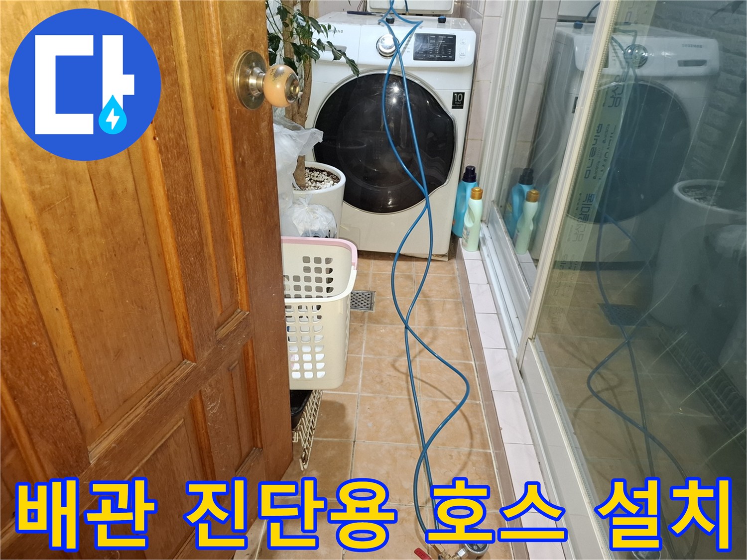 세탁기 옆 바닥에 연결된 파란색 가스 탐지 호스