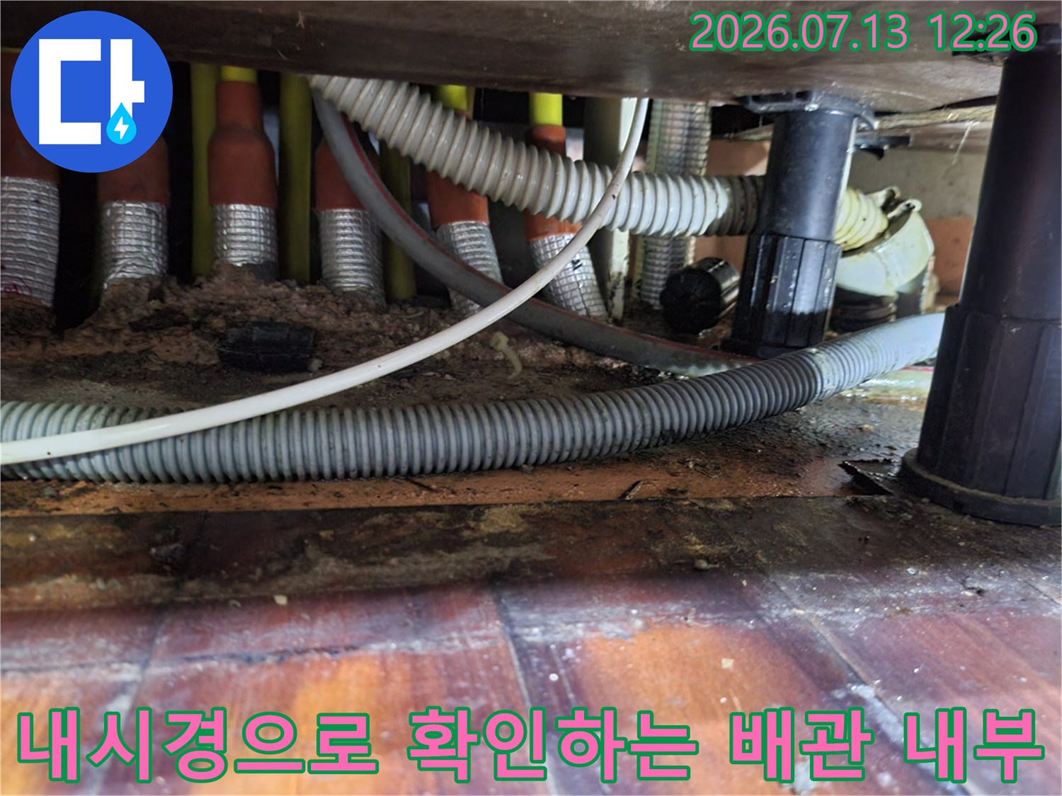 싱크대 하부 공간에서 내시경 카메라로 노후된 배수 호스를 검사함