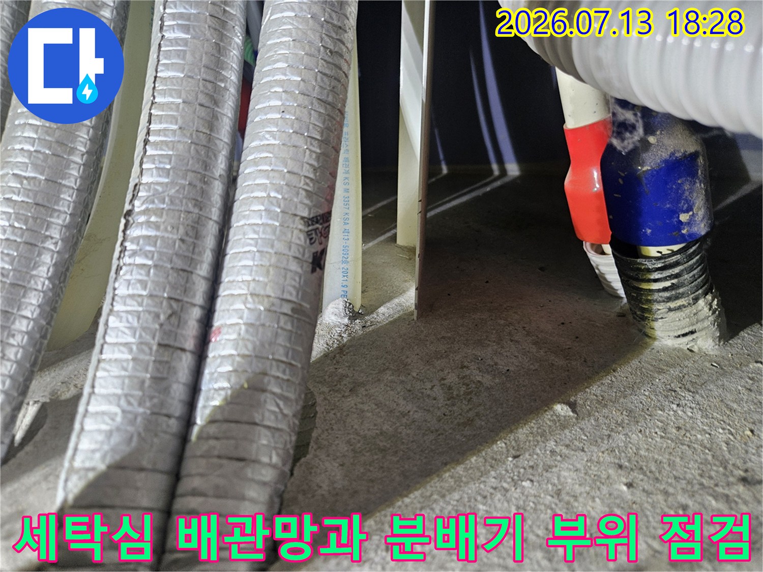 은색 단열재로 감싼 다수의 배관과 파란색 밴드로 고정된 연결부 위치