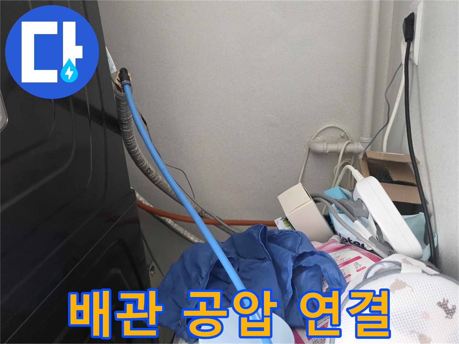 세탁실 주변 배관에 파란색 호스를 연결하여 압력을 가하는 모습